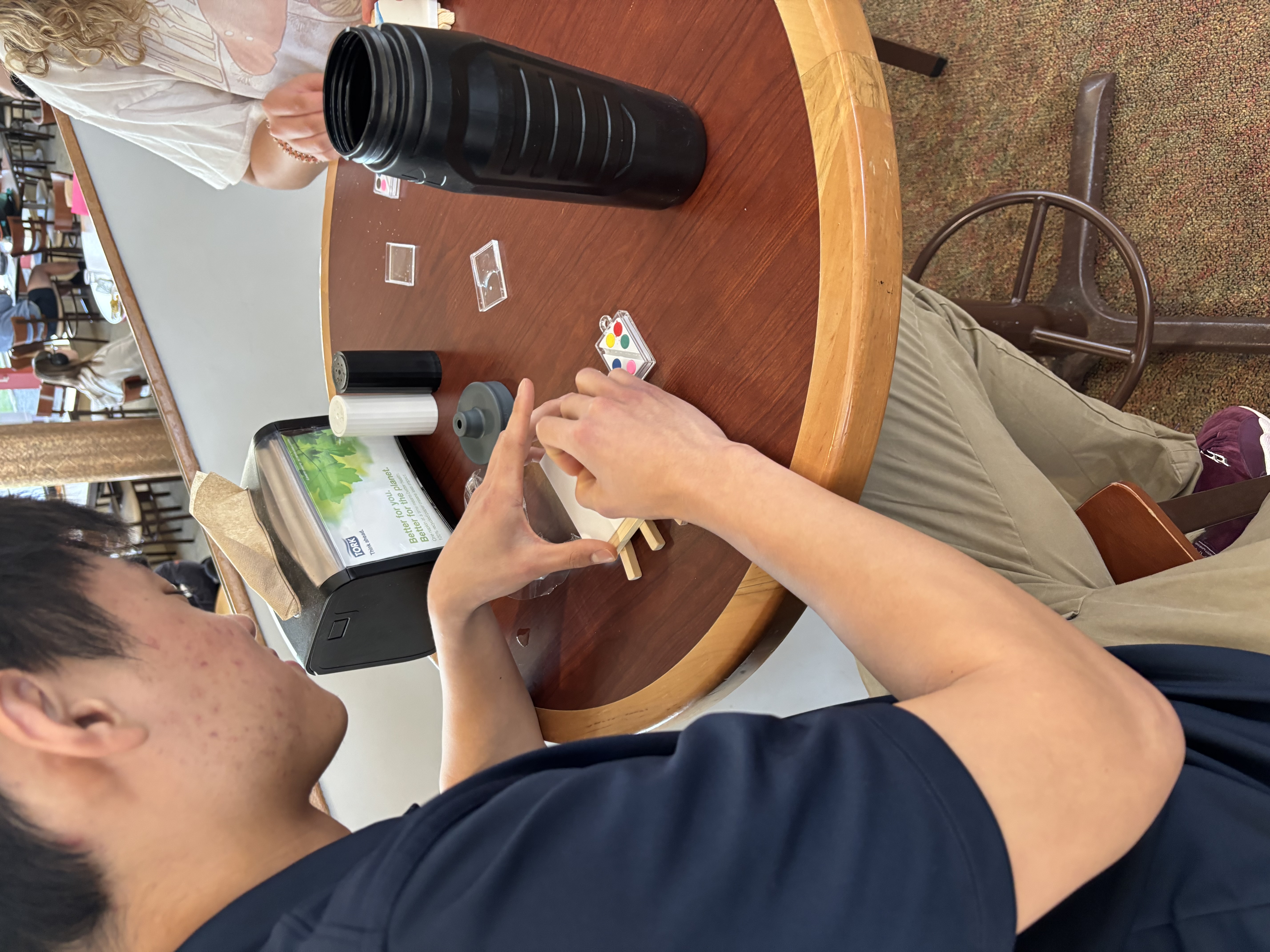 student painting on a mini canvas